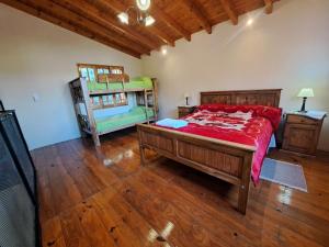 a bedroom with a large bed with a red bedspread at AMANECER DORADO - Cabaña en Tunuyán in Tunuyán