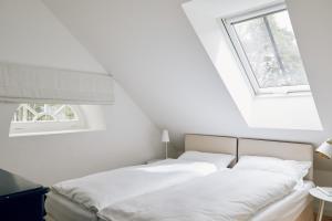 a bedroom with a bed and two windows at Schmiede in Barkelsby