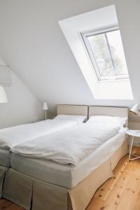 a bed in a white room with a window at Schmiede in Barkelsby