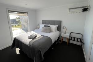 Un dormitorio con una cama con una toalla. en BINALONG BRAE @ Bay of Fires Two bedroom both with ensuites, en Binalong Bay