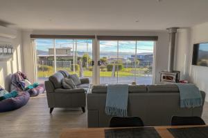 a living room with two couches and a large window at BINALONG BRAE @ Bay of Fires Two bedroom both with ensuites in Binalong Bay