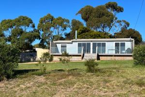 a house on a field with trees in the background at BINALONG BRAE @ Bay of Fires Two bedroom both with ensuites in Binalong Bay
