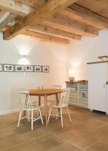 a kitchen and dining room with a wooden table and chairs at Schmiede in Barkelsby +20 photos