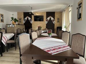 a dining room with a table and chairs at Casa Maramureșană in Vişeu de Sus