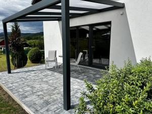 a patio with two chairs and a table and windows at Apartmány DEER House in Hodkovice nad Mohelkou