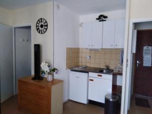 a kitchen with white cabinets and a sink at Studio Barbotan in Barbotan-les-Thermes +5 photos