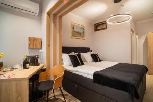 a small bedroom with a bed and a desk and a desk at i3 Boutique Apart in Bacău