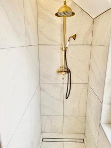 a shower with a gold shower head in a bathroom at Confort et Nature à Berck-Plage - détente ou travail - wifi in Berck-sur-Mer