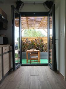 uma porta aberta para um pátio com uma mesa em Chambre studio aménagé em Cers