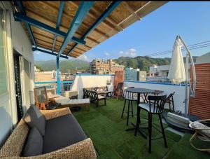a balcony with a couch and tables and chairs at Ryokan La Luna in Ukusu