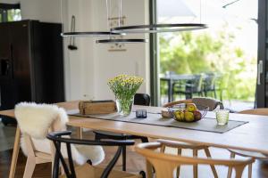 a dining room table with a bowl of fruit on it at Eifel21 - stilvolles Haus in der Vulkaneifel in Bleckhausen