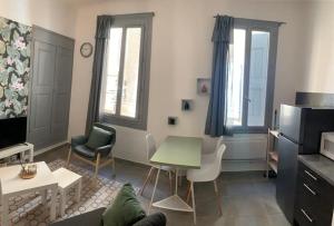 ein Wohnzimmer mit einem Sofa und einem Tisch in der Unterkunft Studio cosy, rénové en plein centre-ville in Manosque