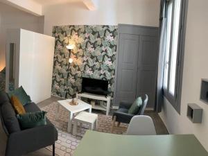 ein Wohnzimmer mit einem Sofa, Stühlen und einem Kamin in der Unterkunft Studio cosy, rénové en plein centre-ville in Manosque