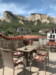 a patio with a table and chairs and a mountain at Сининкова Къща in Melnik