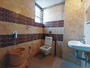 a bathroom with a toilet and a sink at STAYMAKER Shri Shakti Residency in Hubli