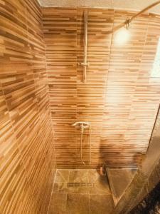 y baño con ducha y pared de madera. en Guest house Nizama's Place, en Sarajevo