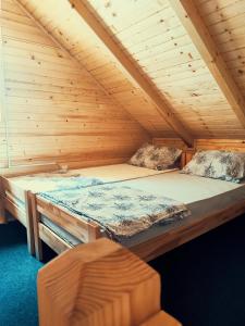 a bed in a cabin with a wooden ceiling at Guest house Nizama's Place in Sarajevo