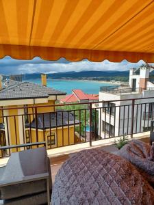 a balcony with a bed and a view of the city at Apartments Provence in Sozopol