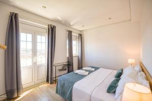 a bedroom with a bed and a large window at Feel Porto Historical Apartments in Porto