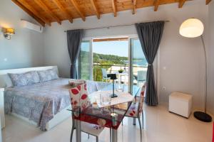 um quarto com uma cama e uma mesa de vidro em Villa Avgerini Paxos em Gaios