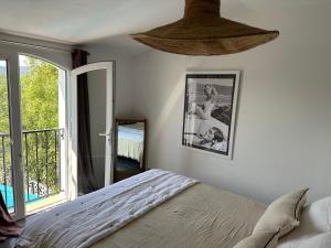 a bedroom with a bed and a large window at mazet proche de st Tropez in Cogolin