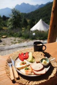 a plate of food with eggs and bread and a cup of coffee at Ursa Camp Mountain Glamping in Gornje Lipovo