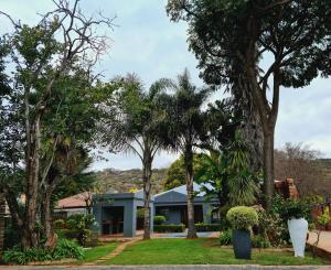 ein Haus mit Bäumen davor in der Unterkunft Maison Akiba in Pretoria