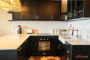 a kitchen with black cabinets and a sink at A luxury apartment in Malta’s capital Valletta in Valletta