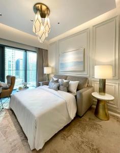 a bedroom with a large white bed and a chandelier at Luxurious one-bedroom very close to Dubai Mall in Dubai