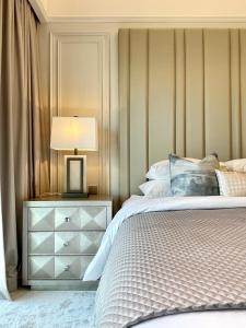 ein Schlafzimmer mit einem Bett und einem Nachttisch mit einer Lampe in der Unterkunft Luxurious one-bedroom very close to Dubai Mall in Dubai