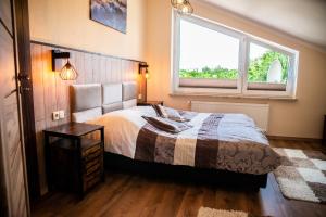 a bedroom with a bed and a window at MAJA - Apartamenty na fali in Władysławowo