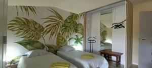 2 Betten in einem Zimmer mit Pflanzen an der Wand in der Unterkunft le Moulin des Moines in Châtenois