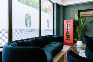 a living room with a black couch and a red phone booth at Highgarden Hotel in Tbilisi City