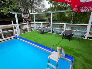 a swimming pool with chairs and a table and an umbrella at Hotel River View bihac in Lohovo