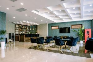 a lobby with a bar and tables and chairs at Highgarden Hotel in Tbilisi City