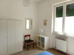 a bedroom with a chair and a dresser and a window at Casa Felci in Tirrenia