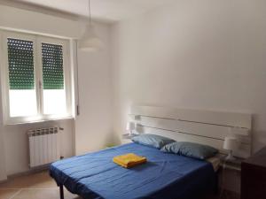 a bedroom with a blue bed and a window at Casa Felci in Tirrenia