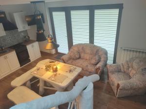 een woonkamer met 2 stoelen en een tafel bij GuestHouse III in Lesko