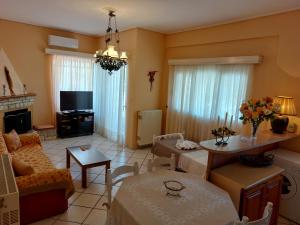 a living room with a couch a table and a tv at Oranje Guesthouse in Itea