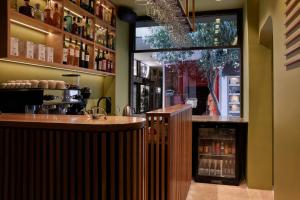 a bar in a restaurant with a large window at DWELL - Elegant City Stay in Athens