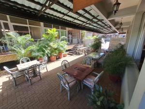 an outdoor patio with tables and chairs and plants at Moshi Leopard Hotel in Moshi
