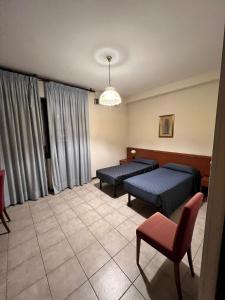 a hospital room with two beds and a chair at Hotel Colonna in Albignasego