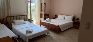 a hotel room with two beds with shoes on them at Ta Adelfia in Pylos +129 photos