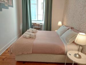 a bedroom with a large bed with two stuffed animals on it at Estrela Charming Rooms 2 by HOST-POINT in Lisbon +24 photos