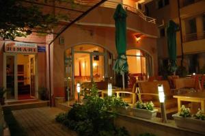 restauracja z patio ze stołami i parasolami w obiekcie Villa Rimari w Ochrydzie