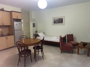 a kitchen with a table and a room with a bed at Miranda's Apartments & Rooms in Sarandë