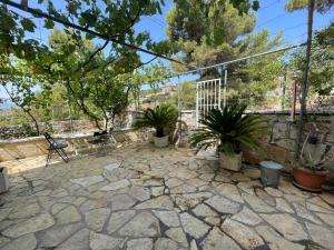 eine Terrasse mit Topfpflanzen und einer Steinmauer in der Unterkunft Miranda's Apartments & Rooms in Sarandë
