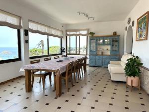 een eetkamer met een tafel en stoelen en de oceaan bij LETS HOLIDAYS Beautiful house sea views in Tossa de Mar