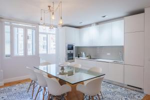 a kitchen with a glass table and white cabinets at Feel Porto Downtown Apartments & Studios in Porto