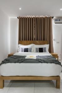 a bedroom with a large bed with a wooden headboard at The Avery Apartments at Odomaa Place, East Airport in Accra